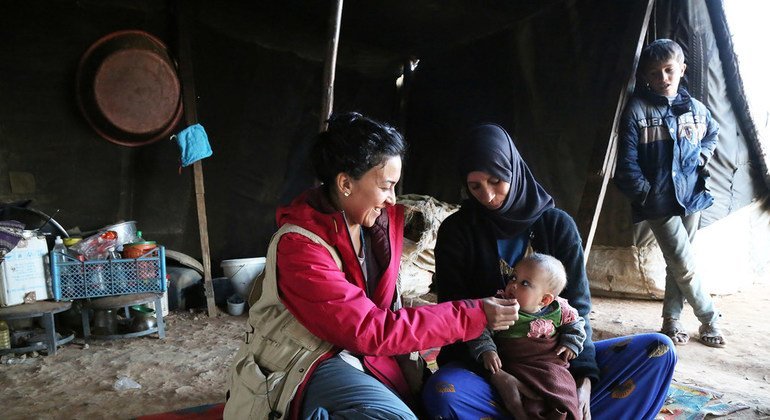 Una madre y su hijo junto  una trabajadora del PMA en el campamento de Rukban en Siria