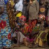 Wakimbizi wakikusanyika katika soko la pamoja katika Kambi ya Wakimbizi ya Nyarugusu, Tanzania, huku mkuu wa UNHCR Filippo Grandi akitembelea.