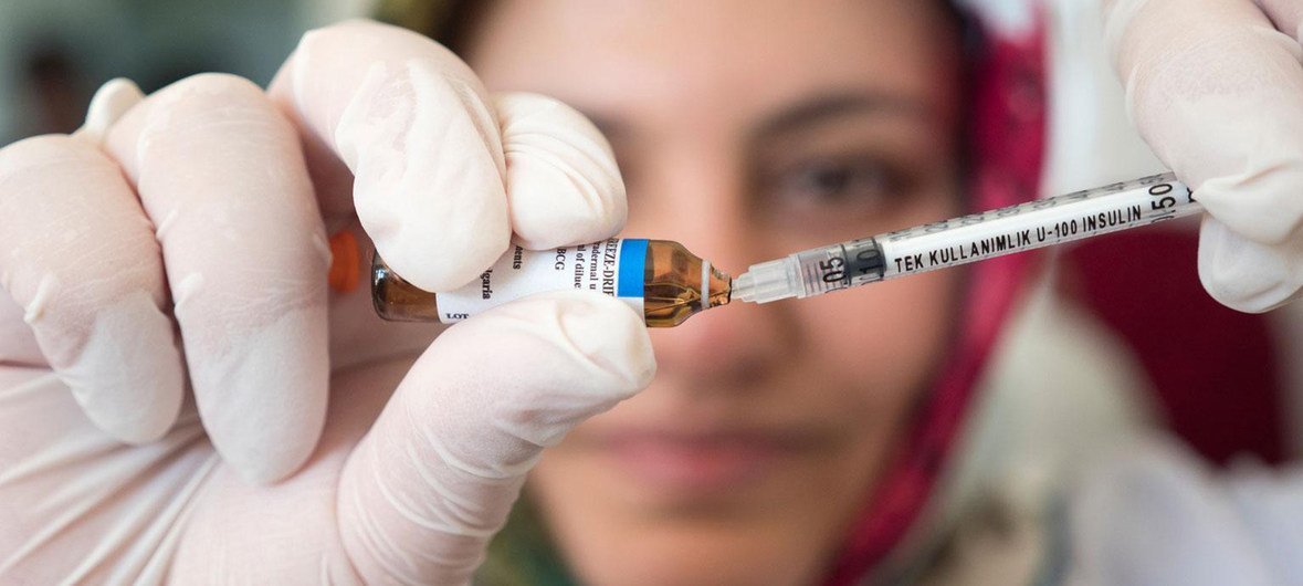 Une infirmière prépare un vaccin.