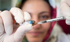 Une infirmière prépare un vaccin.