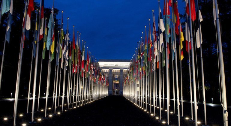 Vue de nuit des drapeaux flottant aux Nations Unies à Genève.