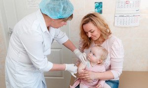 Dana, held by her mother Inna, doesn’t cry while being administered her first dose of mumps, measles and rubella (MMR) vaccine at Children’s Policlinic №1 in Obolon district, Kyiv, Ukraine. (file)