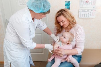 Dana, held by her mother Inna, doesn’t cry while being administered her first dose of mumps, measles and rubella (MMR) vaccine at Children’s Policlinic №1 in Obolon district, Kyiv, Ukraine. (file)
