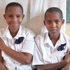 两名女孩在卢旺达马萨卡的小学接受宫颈癌疫苗接种。他们正在加入卢旺达不断增长的年轻人群，为未来可能发生的宫颈癌做好准备。