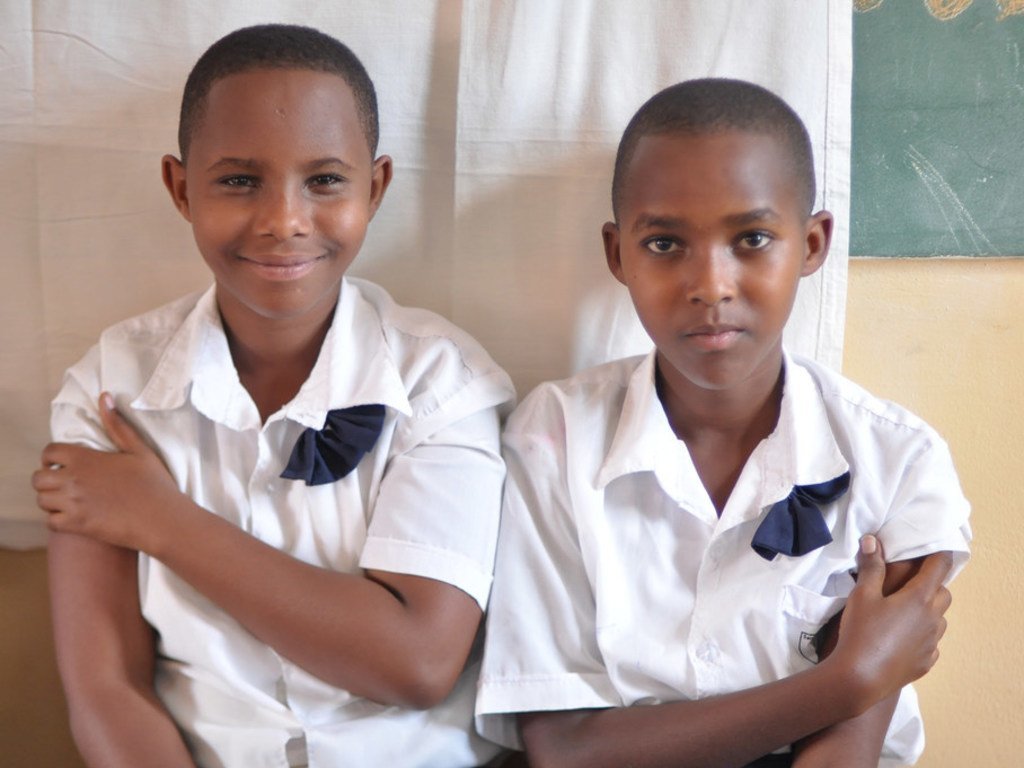 Deux filles assises ensemble après avoir été vaccinées contre le VPH dans leur école primaire à Masaka, au Rwanda. Elles rejoignent une population croissante de Rwandaises qui peuvent espérer un avenir sans cancer du col utérin.