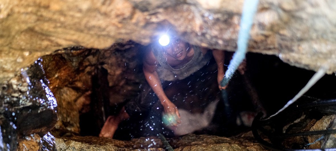 Camarines Norte, the Philippines: An artisanal miner ascends from a shaft in the hills outside of Paracale.