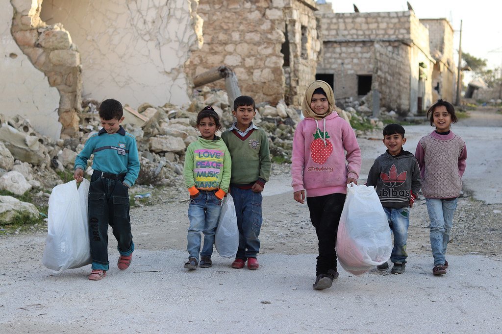 Des enfants syriens rentrant chez eux après avoir choisi des vêtements d'hiver grâce à un programme soutenu par l'UNICEF