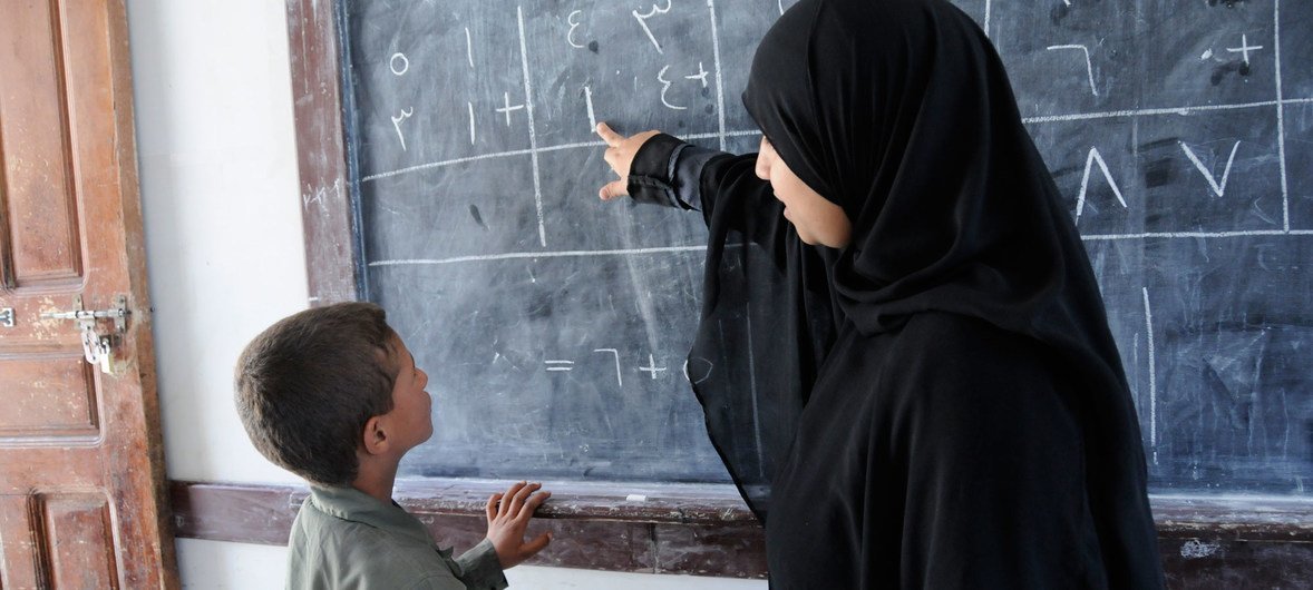 Uma professora iemenita atende um aluno com deficiência auditiva na Associação para o Bem-Estar e Reabilitação de Surdos e Mudos. 