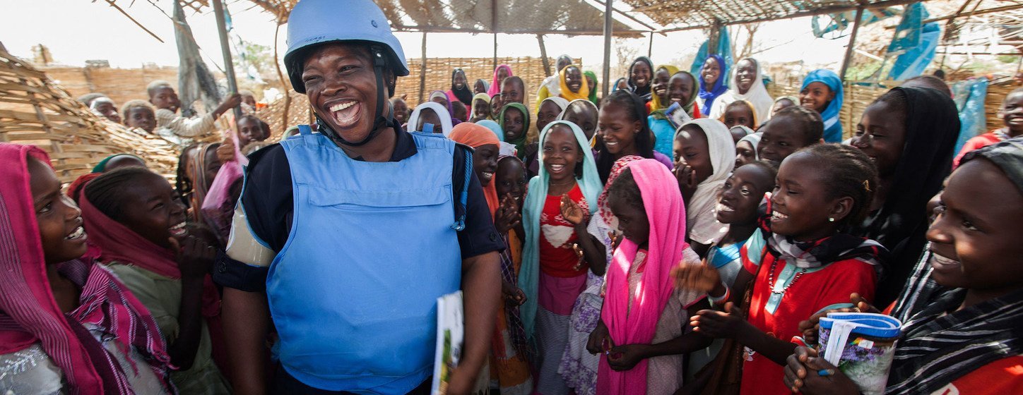 Ghana has been a consistent contributor to United Nations peacekeeping efforts since the 1960s. Seen here is Mary, a UN Police Officer from Ghana, as she greets children at the El Sereif camp for internally displaced persons in the Darfur region of Sudan in June 2014. 