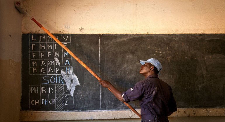 A member of the Ghana Engineering Contingent serving with the UN Multidimensional Integrated Stabilization Mission in Mali (MINUSMA) paints a wall of school in Taliko, a poor neighbourhood of the capital, Bamako.