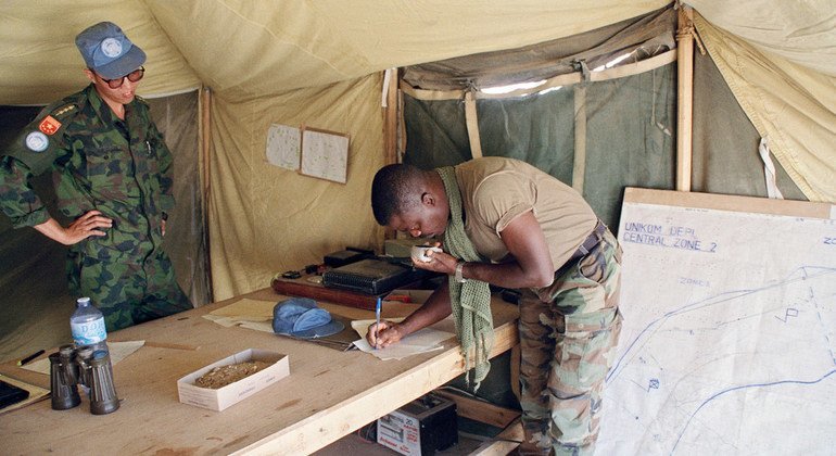 Soldiers from Ghana (on radio) and China at work in the Central Sector of the demilitarized zone along the Iraq-Kuwait border in May 1991. The zone extended 10 kilometres into Iraq and five kilometres into Kuwait from the boundaries as agreed to in 1963.