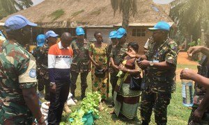 Tanzanian peacekeeper, Ahmed Liuma (far right) serving with MONUSCO’s FIB force in Mavivi, Beni Town in the the Democratic Republic of the Congo, DRC’s province of North Kivu explaining to women farmers on how to sustainably farm vegetables for both selling and household consumption.