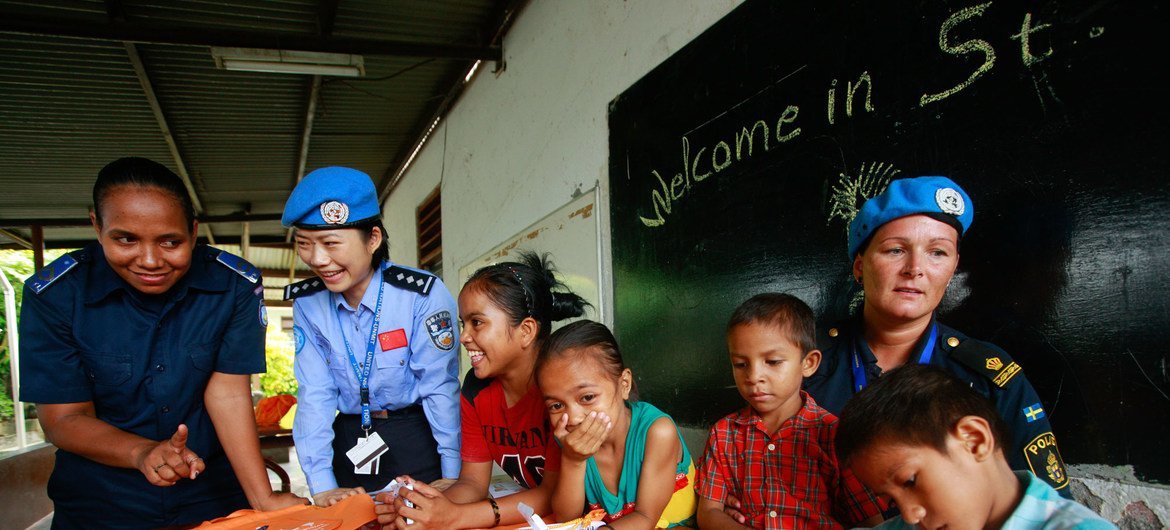 (من الأرشيف) ضباطة شرطة سويدية وزميلتها الصينية من في بعثة الأمم المتحدة في تيمور ليشتي وهما في دار للأيتام في العاصمة ديلي.