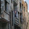 Mwanamke akiwa akiwa amesimama katika nyumba yake katika viunga vya El Khalideh, mjini Homs Syria. (Machi 2019)