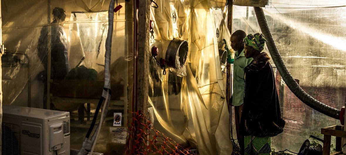काँगो गणराज्य के बेनी इलाक़े में बना एक चिकित्सा केन्द्र, ईबोला संक्रमण के सन्देह में अपनी 15 वर्षीय बेटी की जाँच-पड़ताल देखते हुए माता-पाता. (जनवरी 2019)