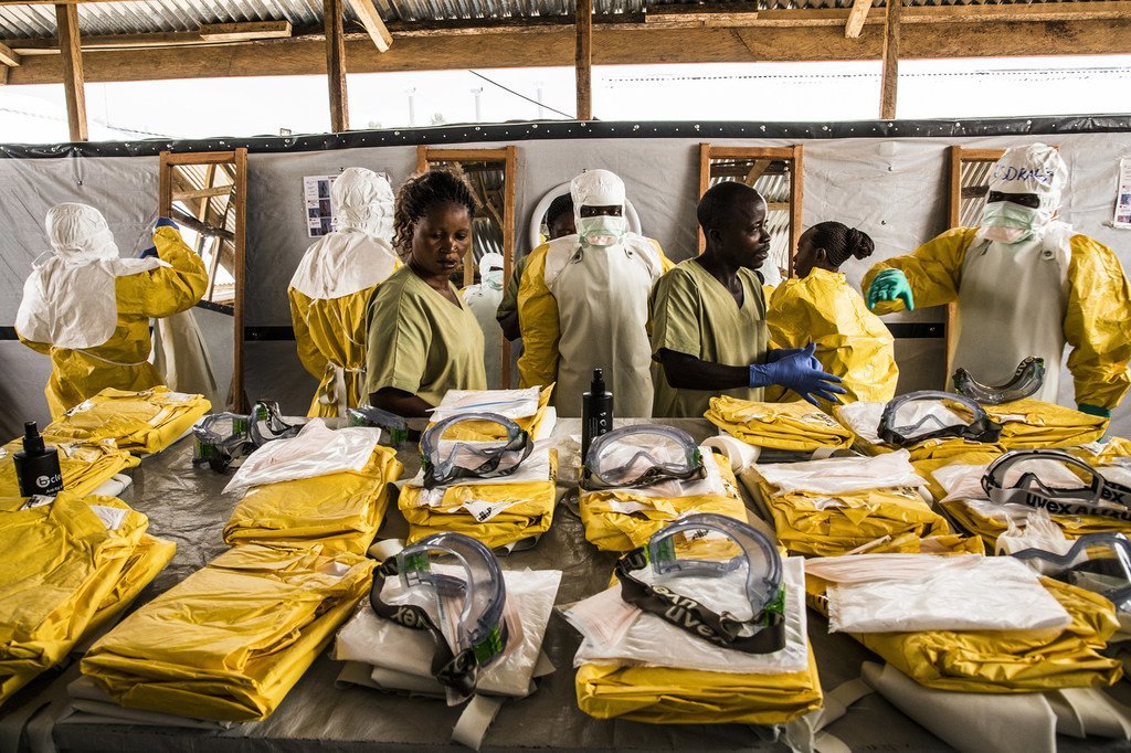 Des agents de santé revêtent leur équipement de protection individuelle avant d'entrer dans la zone où les personnes potentiellement atteintes du virus Ebola sont placées en quarantaine pour être suivies et traitées (janvier 2019).