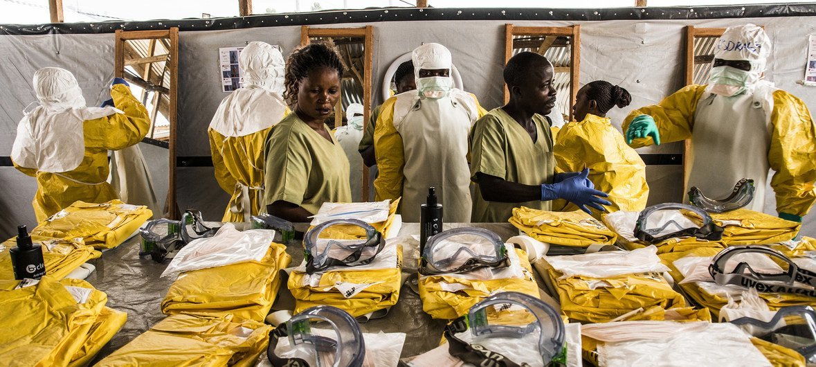 En RDC, des agents de santé revêtent leur équipement de protection individuelle avant d'entrer dans la zone où les personnes potentiellement atteintes du virus Ebola sont placées en quarantaine pour être suivies et traitées (janvier 2019).
