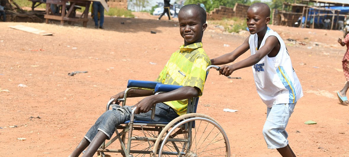 Massouron Camara, de 18 anos, da Côte d'Ivoire, empurrado na sua cadeira de rodas pelo irmão, Abib