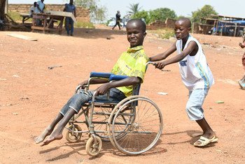 Massouron Camara, de 18 anos, da Côte d'Ivoire, empurrado na sua cadeira de rodas pelo irmão, Abib
