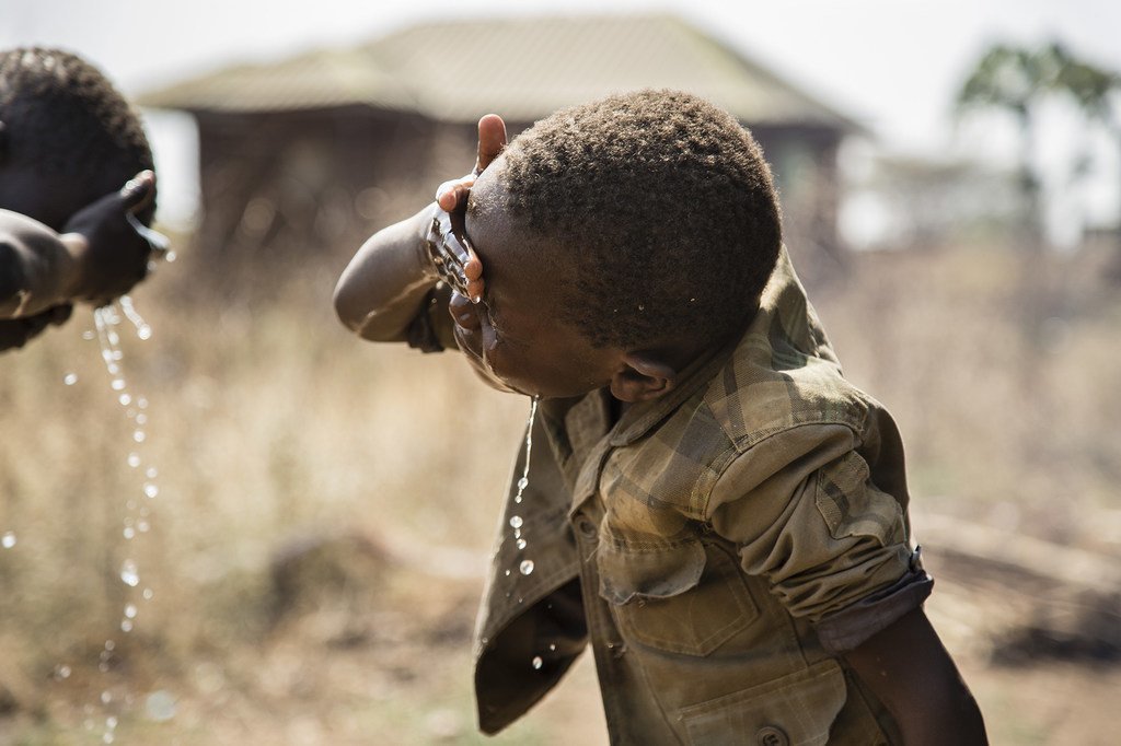 南苏丹，两名儿童正在家门外洗脸。 