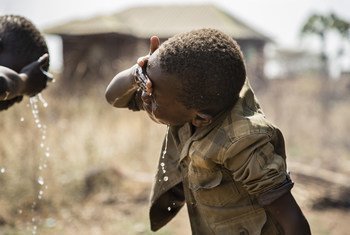 दक्षिण सूडान में घर से बाहर मुंह धोते बच्चे.