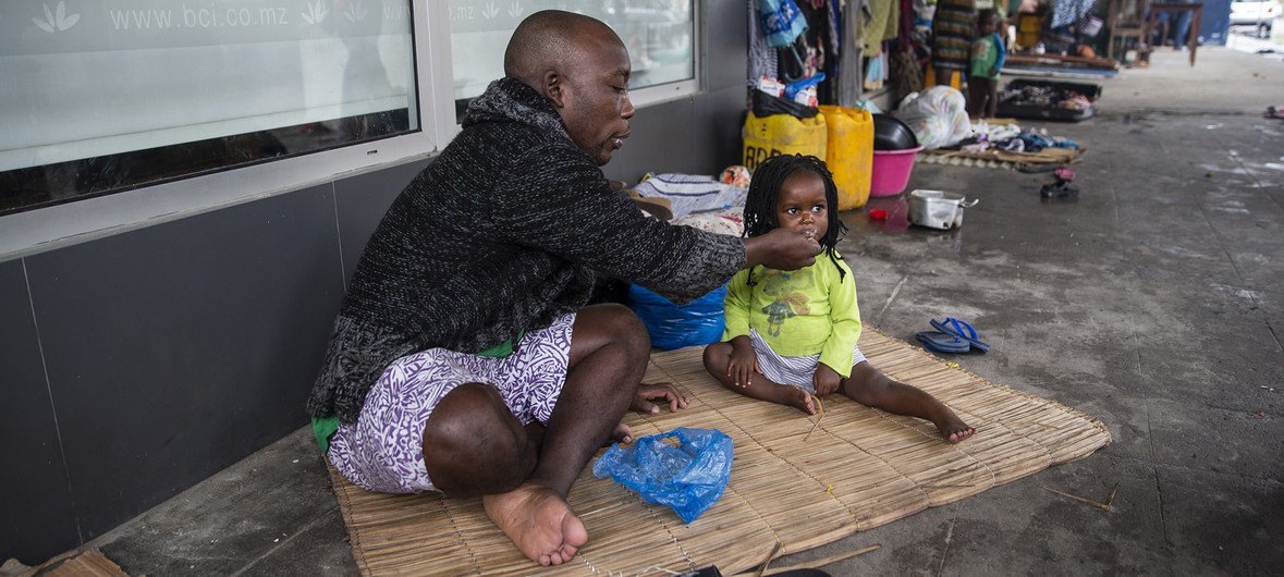 Tome Raimunda dá de comer a uma criança da sua família, Teraza. A família ficou sem casa depois do ciclone Idai. 