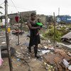 2019年3月20日，塞西莉亚·博尔赫斯带着她的儿子穿过莫桑比克贝拉被热带气旋“伊代”毁坏的一处非正式定居点。