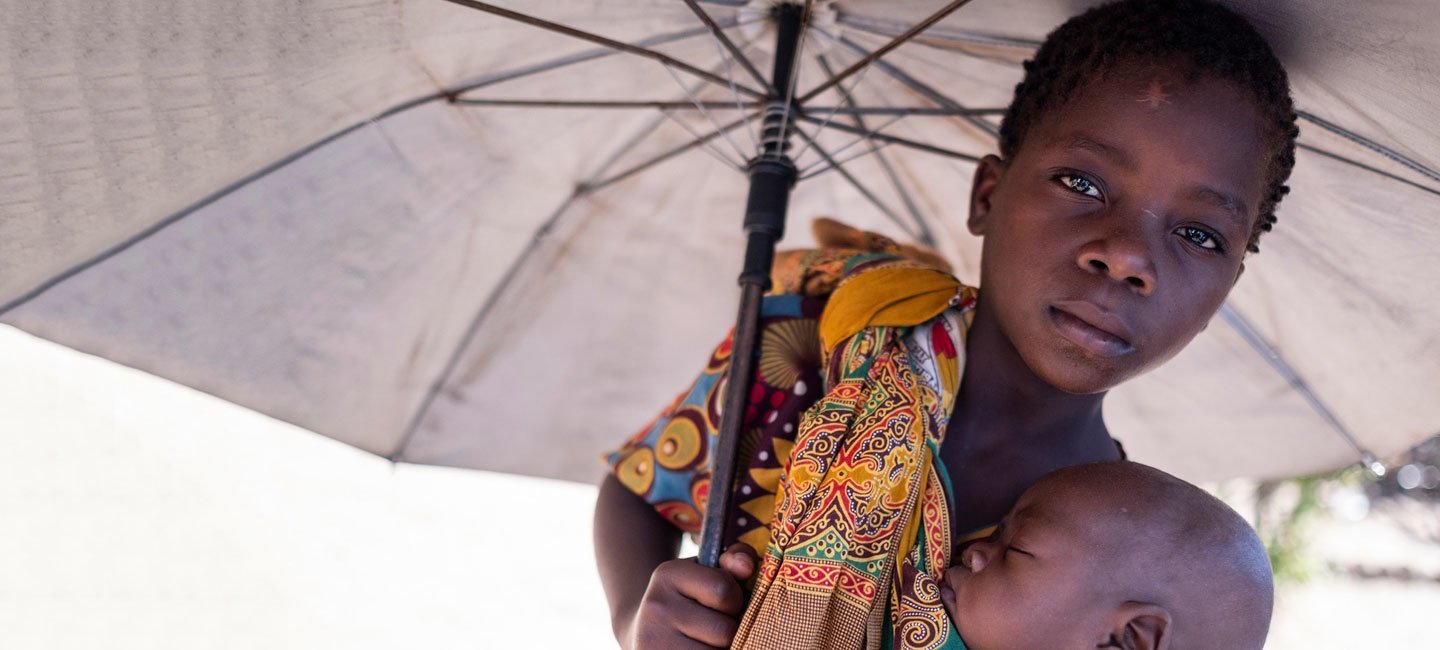 Aruminda sostiene a su hermano, Antonio, en un campo para desplazados en Dondo, Mozambique. El ciclón Idai desplazó a miles de personas