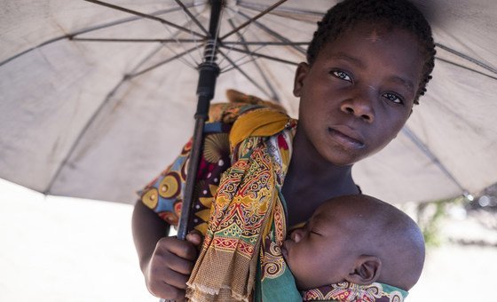 Aruminda segura o irnão, António, em um campo para deslocados em Dondo, Moçambique