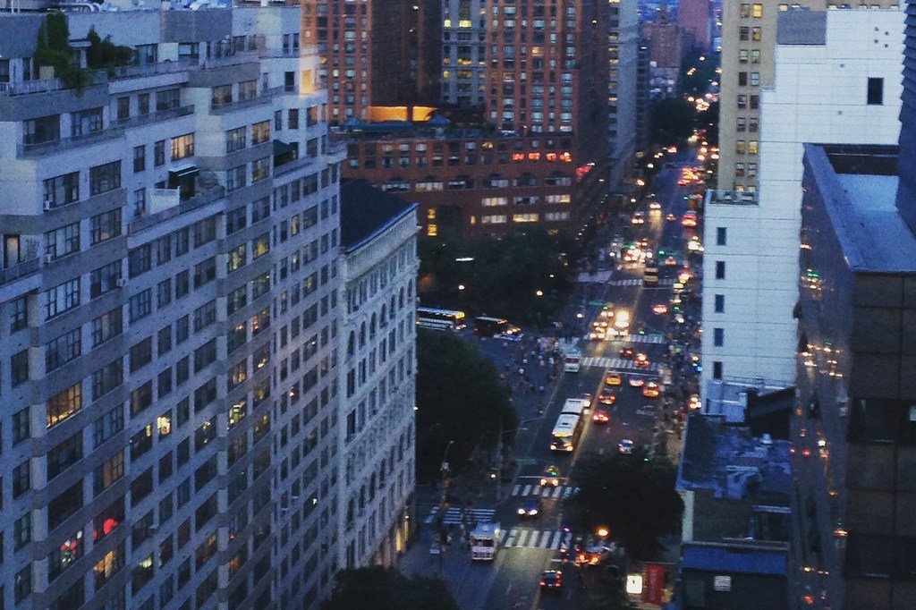 黄昏时分，繁忙的纽约市街道的高角度俯瞰图，下方道路上车流不息，摩天大楼灯火通明。
