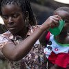 Une mère donne de l'eau à son enfant à l'école Samora Machel, où des gens ont trouvé refuge après que leurs maisons ont été détruites par les inondations à Buzi, au Mozambique.