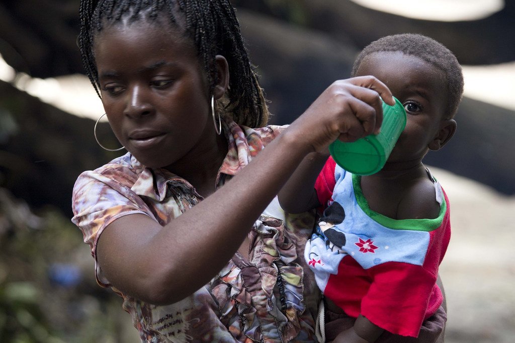 Une mère donne de l'eau à son enfant à l'école Samora Machel, où des gens ont trouvé refuge après que leurs maisons ont été détruites par les inondations à Buzi, au Mozambique.