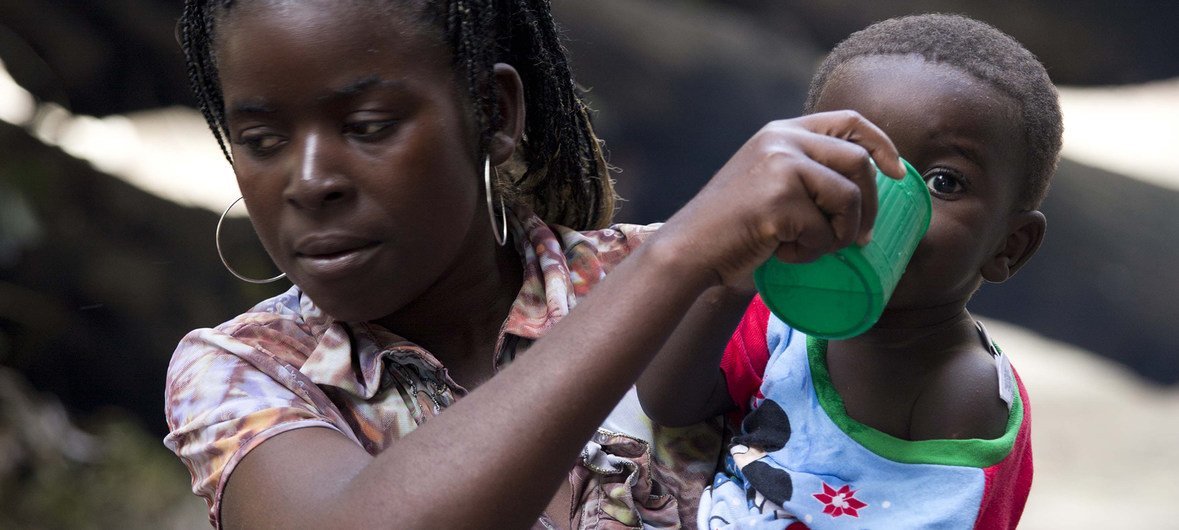 Mãe dá de beber ao filho na Escola Samora Machel, em Búzi, que acolhe deslocados do ciclone Idai