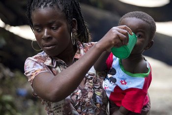 Mãe dá de beber ao filho na Escola Samora Machel, em Búzi, que acolhe deslocados do ciclone Idai