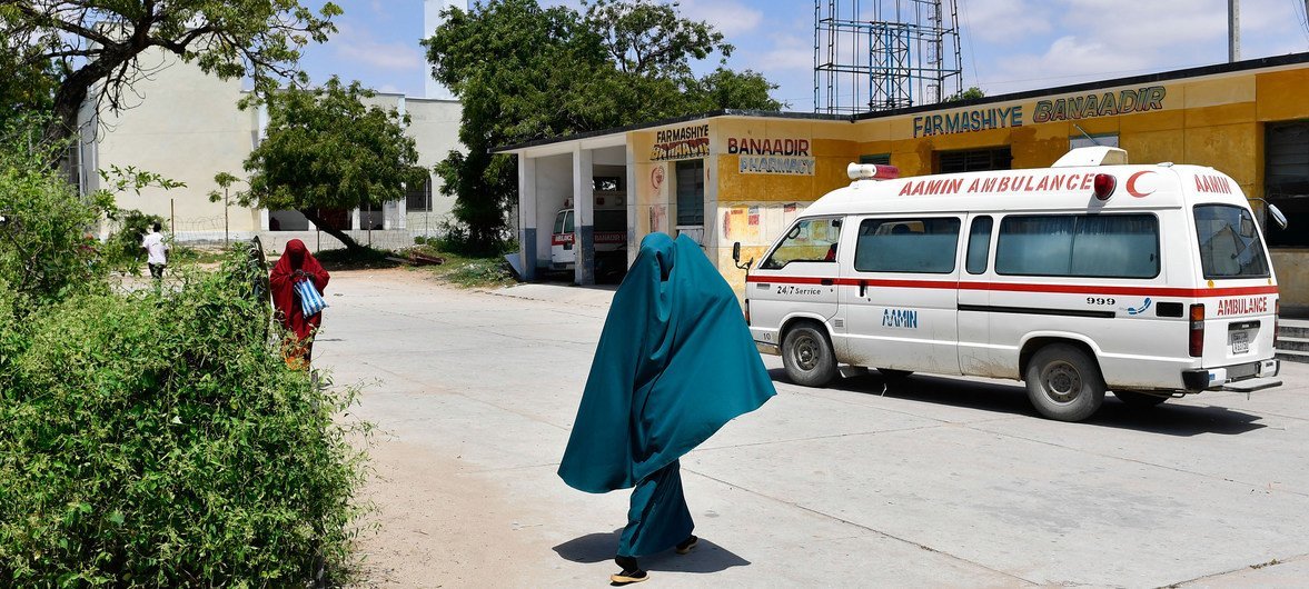 A woman walks past an Aamin Ambulance vehicle inside Benadir Hospital in Mogadishu, Somalia
