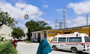 A woman walks past an Aamin Ambulance vehicle inside Benadir Hospital in Mogadishu, Somalia