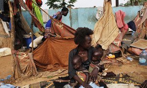 Twins Elizabeth and Madelina, who suffer from malnutrition, are being held by a relative in the street, where they live, in Juba, South Sudan. (2018).