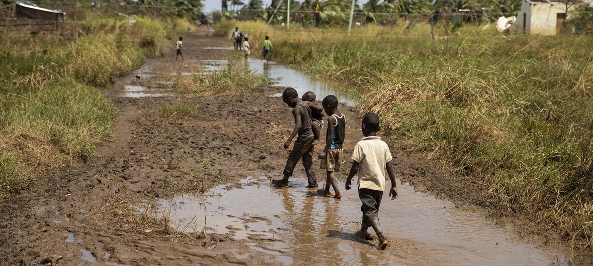 Children are seen walking on a muddy street in Buzi. The flood water from Cyclone Idai is still visible in Buzi, Mozambique.