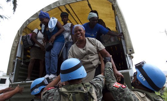 Soldados da paz ajudam pessoas a preparar para uma tempestade no Haiti, em 2010