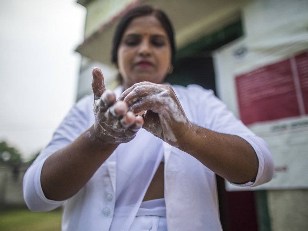 Une infirmière se lave les mains avec du savon avant d'examiner une patiente à Shrawasti, en Inde.