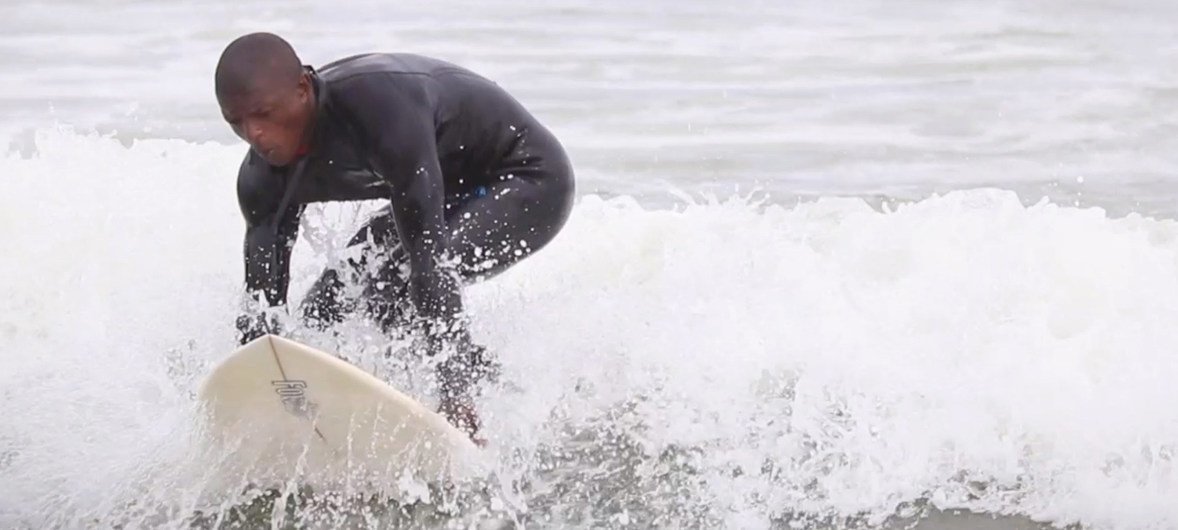 La Ligue mondiale du surf s'est engagée à lutter contre le changement climatique. Dans cette photo,  Thembaletu Khayelitsha un surfeur qui fait partie de l'école de surf Waves for Change surfing school de Cape Town, en Afrique du Sud.