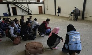 Detainees at a detention centre in Tripoli, Libya, waiting for safe settlement supported by UNHCR. Here, a 19-year-old Eritrean girl talks to a UNOCHA staff member, while waiting her turn to get on the bus for transit to the UNHCR gathering center. She wi