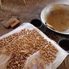 En el interior de una vivienda rural en la zona seca de Myanmar, se están procesando cacahuetes sobre una lámina de plástico.
