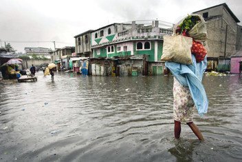 一名妇女走过海地太子港的一个被水淹没的市场，飓风“桑迪”2012年对加勒比海岛屿国家造成了严重破坏。
