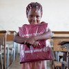 Una niña de seis años recibe un paquete con material educativo de UNICEF en Beira, Mozambique, donde miles de personas se han visto afectadas por el ciclón Idai.