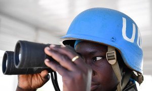 A female Ugandan soldier serving under the United Nations Guard Unit (UNGU) scans the horizon through a pair of binoculars while on duty at a security tower in Mogadishu, Somalia.