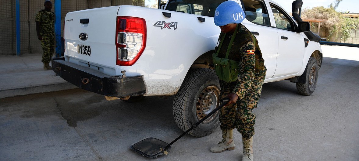 A female Ugandan soldier serving under the United Nations Guard Unit (UNGU) in Somalia, searches a vehicles at a checkpoint in Mogadishu.