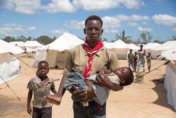 Lucio Carlos, a volunteer social mobiliser, carried Luisa Daniel, 5, suffering from fever and vomiting to a medical tent where she was tested for Malaria. Dondo, Mozambique.