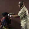 Télesphore Mumbere, ophtalmologue à la clinique de Butembo, ausculte une personne ayant survécu à Ebola.