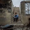 Mohammed, 10, sits on the staircase of the former house he used to hide with his family in Mosul.